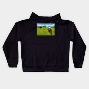 A herd of Holstein Friesian cows grazing on a pasture under blue cloudy sky Kids Hoodie